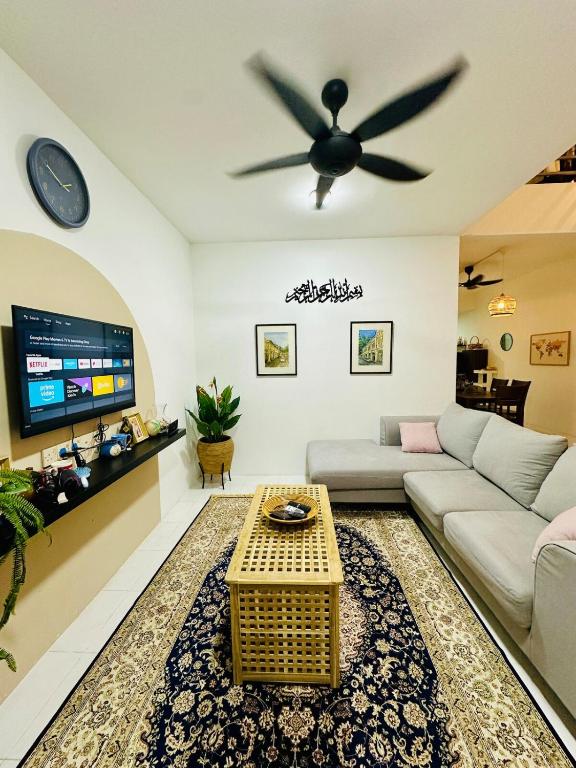 a living room with a couch and a ceiling fan at Cozy All Four Bedroom with Aircond Stay wifi and Netflix in Kampong Bota Road