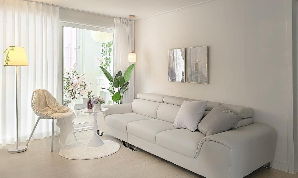 a white living room with a couch and a table at Gyeongju Florian Stay Stay Close Explore More in Gyeongju