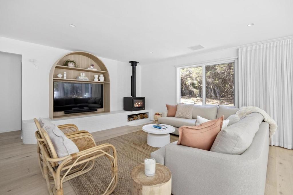 a living room with a couch and a tv at Harlech House Rye in Rye