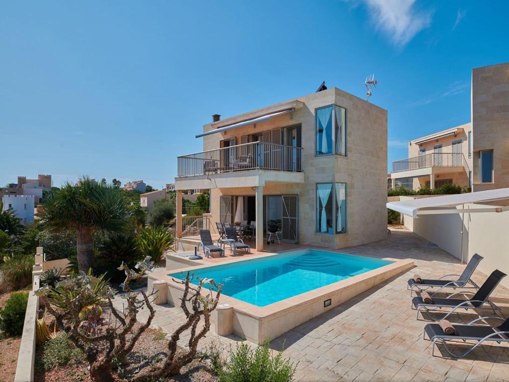 a house with a swimming pool in front of it at Cozy Vista Mar Azul in Cala Murada in Cala Murada