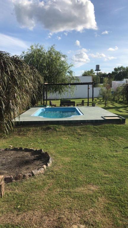 a small swimming pool in a yard with a grass field at El Cardo in General Belgrano