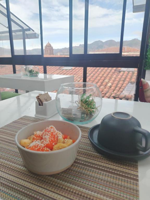 a bowl of food sitting on a table with a plate at Departamento con súper desayuno in Cusco
