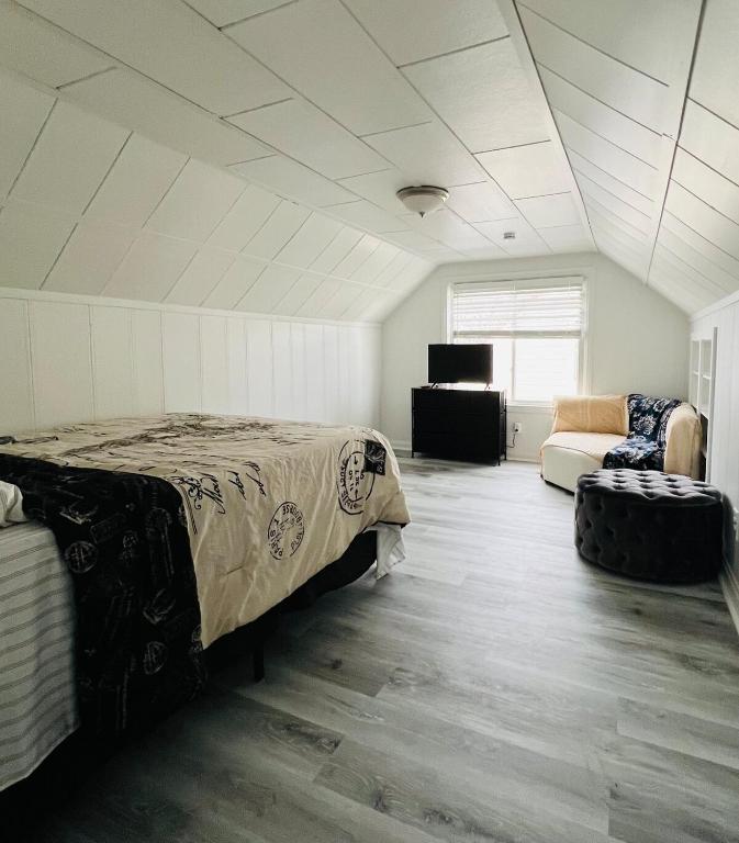 a bedroom with a bed and a couch at Charming & Spacious 3 bedroom Home near Downtown Ferndale, MI in Ferndale