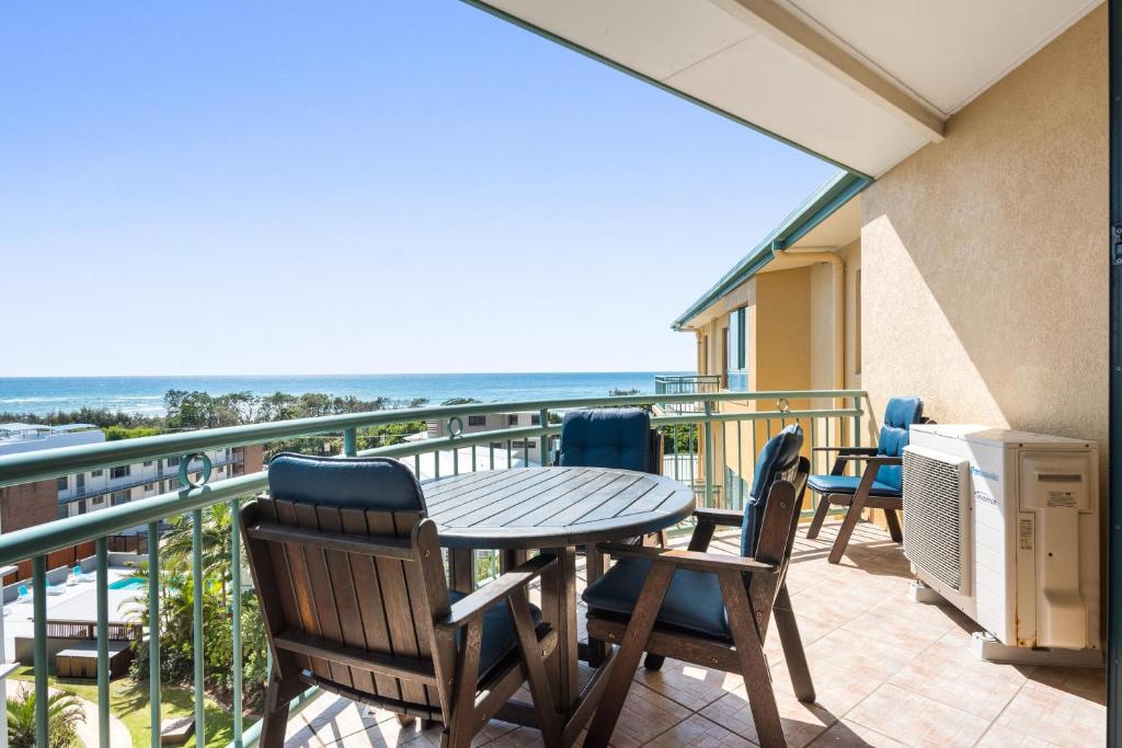 a balcony with a table and chairs and the ocean at Sunshine Towers Boutique Apartments in Maroochydore