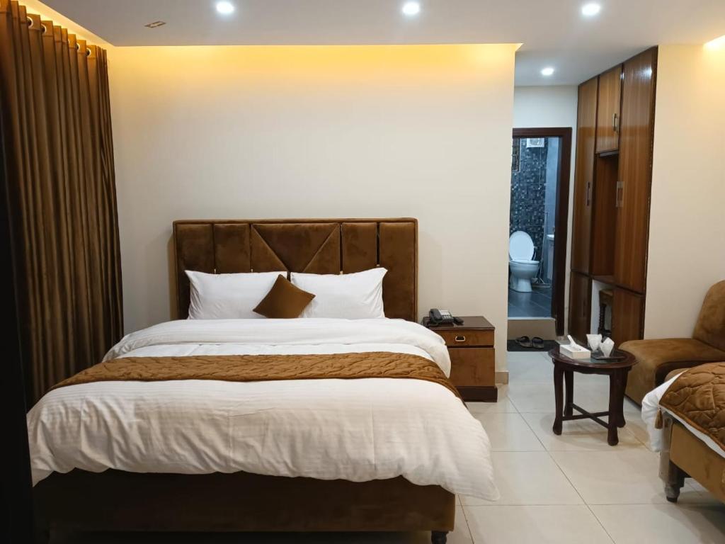 a bedroom with a large bed and a chair at Osama's Room for Rent in Murree