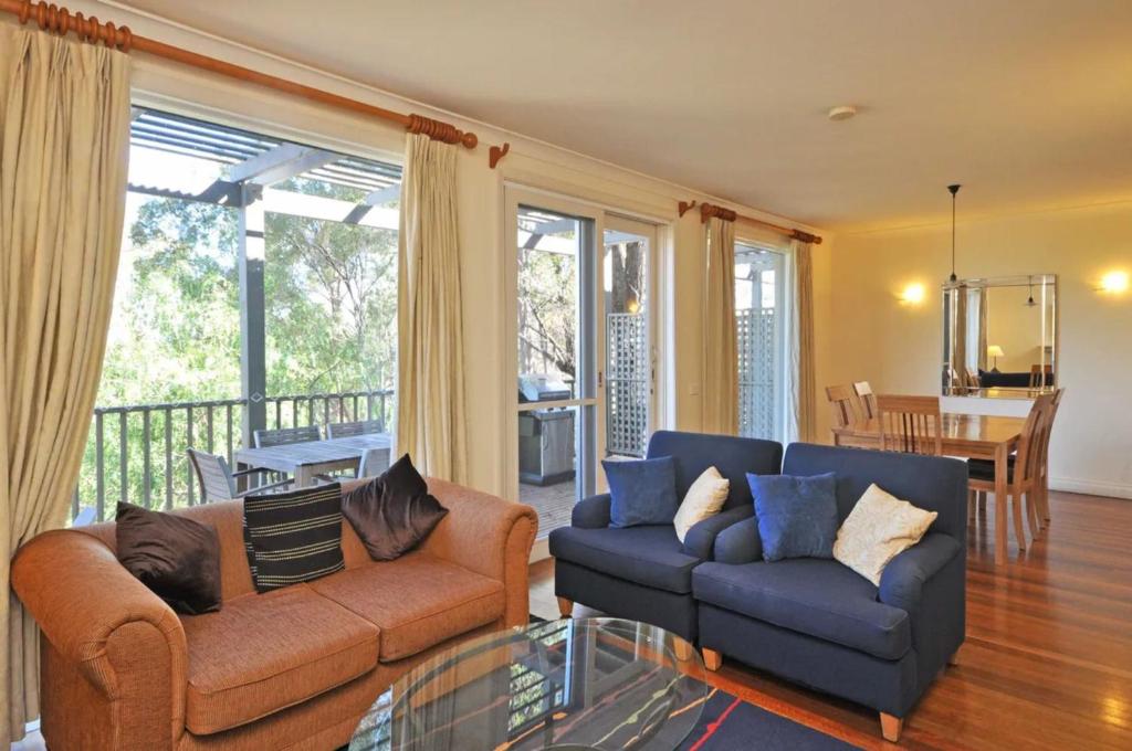 a living room with a couch and a glass table at Villa 2br Petit Verdot Villa located within Cypress Lakes Resort in Pokolbin