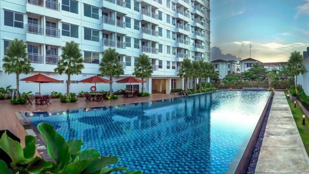a swimming pool in front of a building at Loft Privato, Jakarta in Jakarta