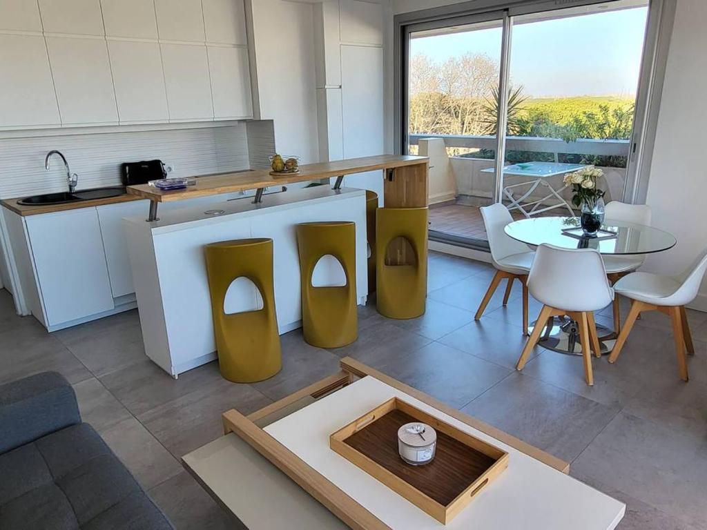 - une cuisine avec un comptoir et une table dans une pièce dans l'établissement Appartement avec Terrasse Lumineuse à La Grande-Motte - FR-1-716-82, à La Grande Motte