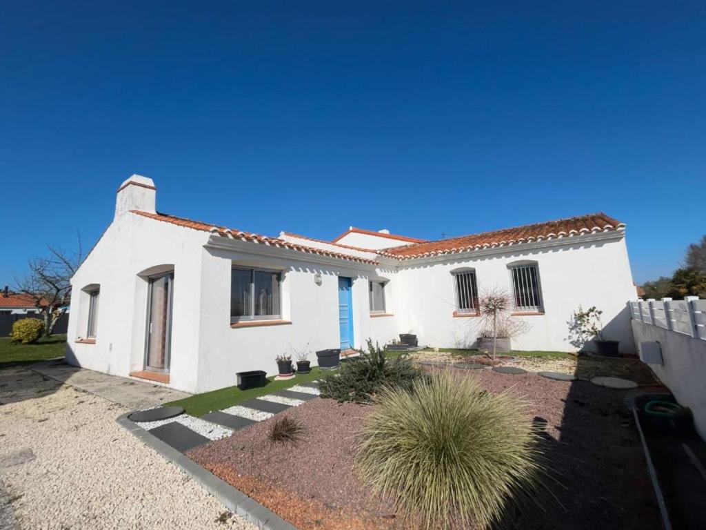 une maison blanche avec une clôture devant dans l'établissement Maison avec véranda, jardin clos, 2 chambres - Proche centre et océan - FR-1-224C-338, à Saint-Jean-de-Monts