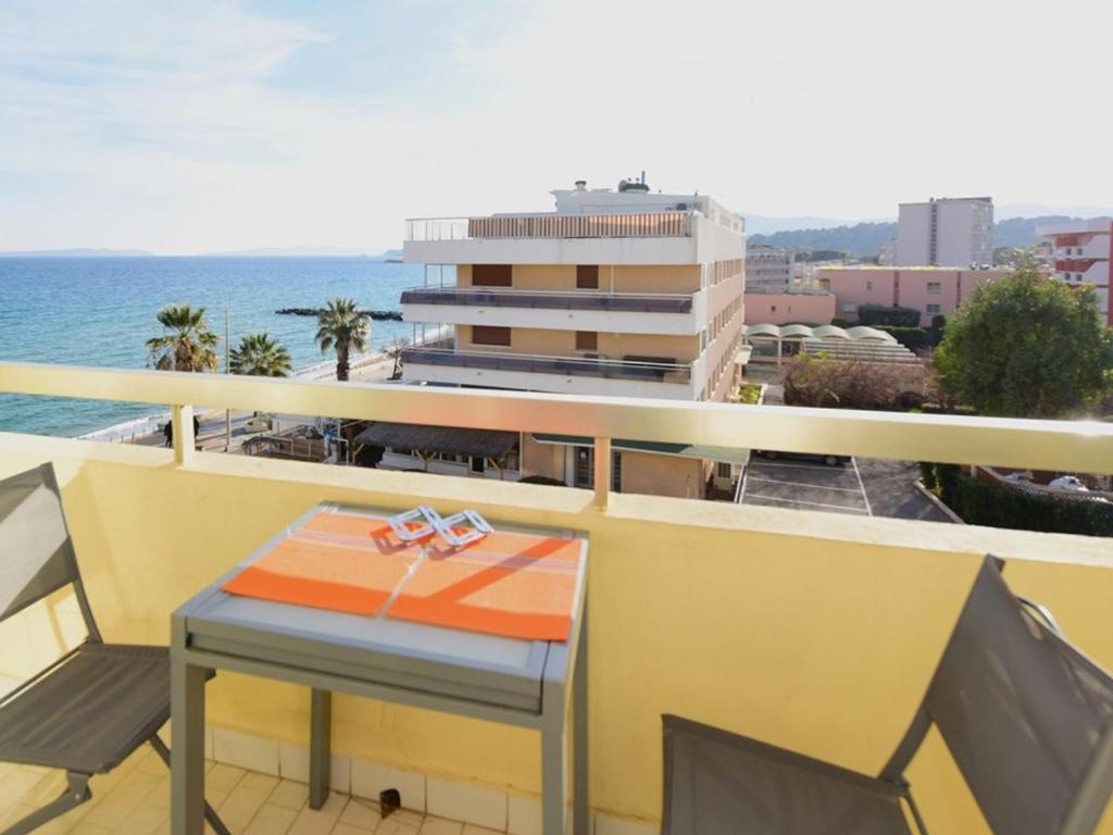 - une table avec cadeau sur un balcon donnant sur l'océan dans l'établissement Le Lavandou: Studio 4 pers. vue mer, parking, clim - FR-1-803-92, au Lavandou