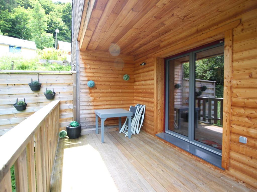- une terrasse couverte en bois avec un banc dans l'établissement Chalet au Mont Dore, 8 pers, proche centre, terrasse - FR-1-608-286, à Mont-Dore