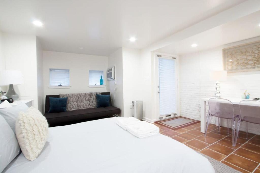 a white bedroom with a bed and a desk at WELL-EQUIPPED STUDIO APT - WALK TO METRO SUBWAY in Washington, D.C.