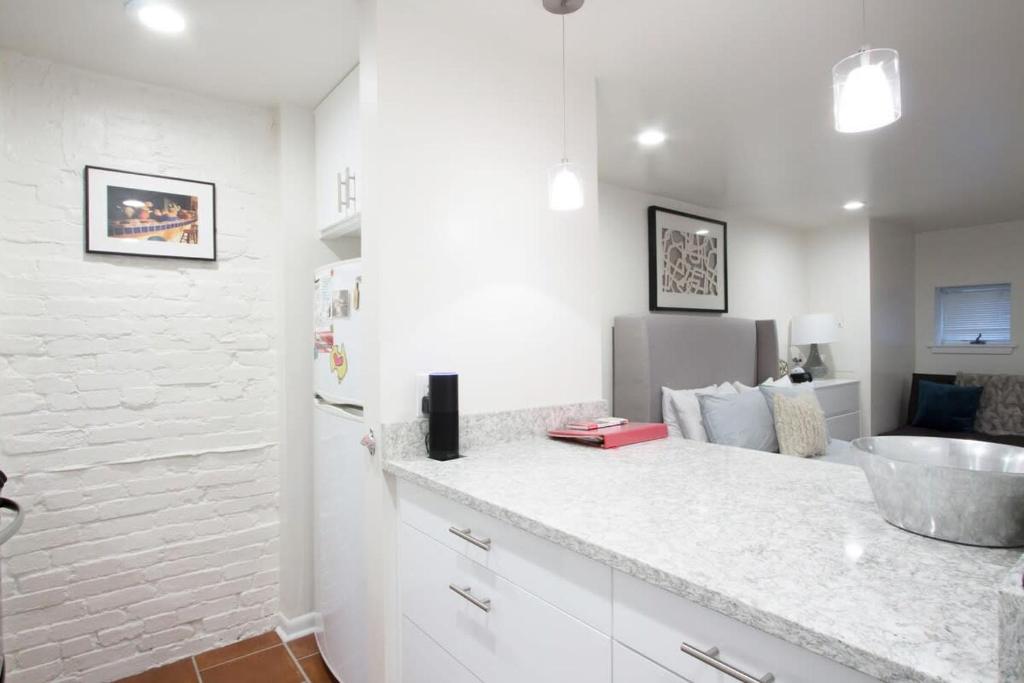 a white kitchen with a sink and a counter at WELL-EQUIPPED STUDIO APT - WALK TO METRO SUBWAY in Washington, D.C.
