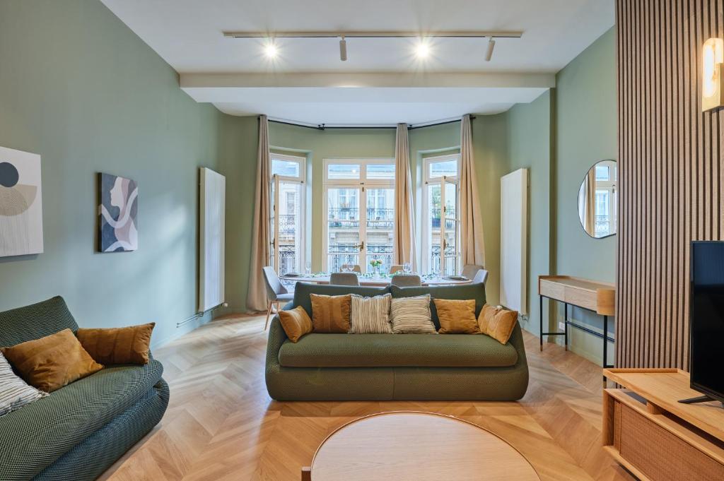 un salon avec un canapé et une télévision dans l'établissement Elegant 2-bedroom apartment - Trocadéro, à Paris