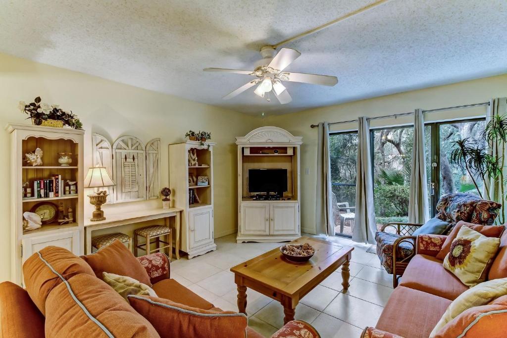 a living room with a couch and a tv at DogFriendly Beachwood Condo in Fernandina Beach