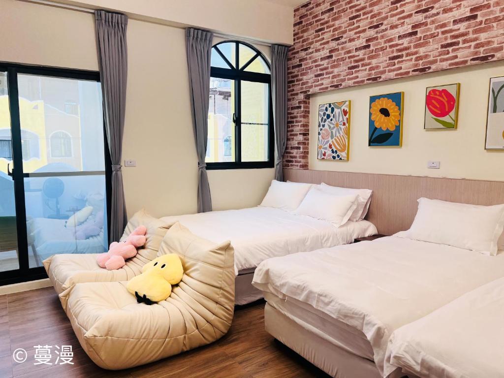 Un dormitorio con 2 camas y un sofá con un pato relleno. en Manman Homestay, en Taitung
