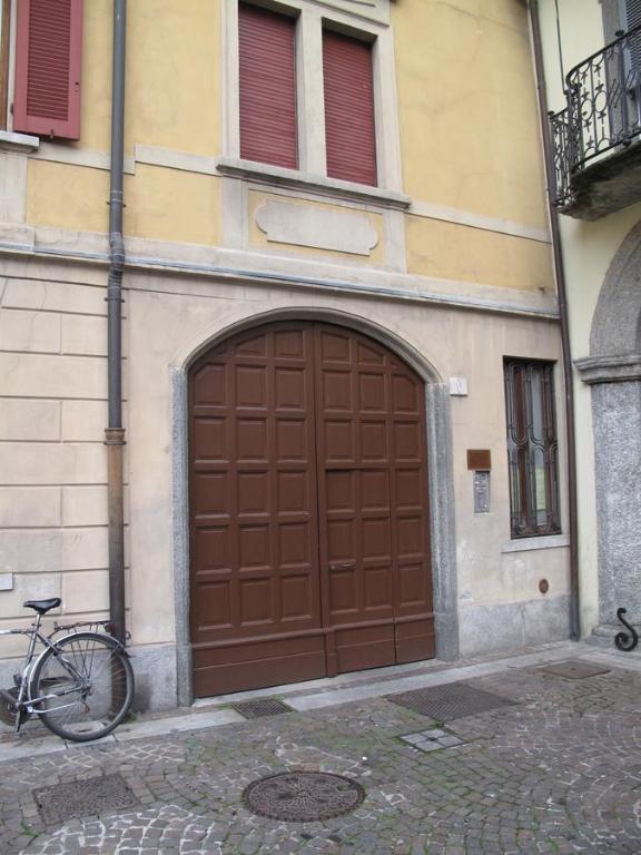 a bike parked in front of a brown garage at Como Luxury Rooms in Como