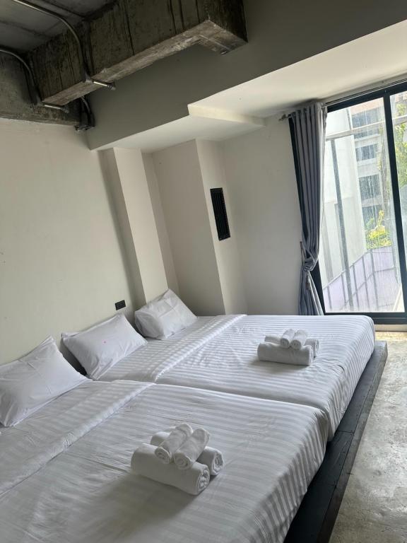 a bedroom with two beds with towels on them at Ella Lamoon in Patong Beach
