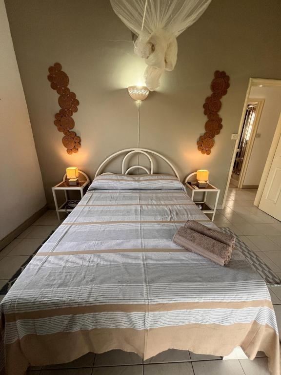 a bedroom with a bed with a blue and white blanket at Baobab 3 Apartment in Grand-Baie