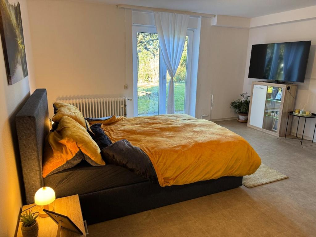 een groot bed in een kamer met een bank bij Apartment Schwarzwaldhöhen Pforzheim-Birkenfeld in Birkenfeld