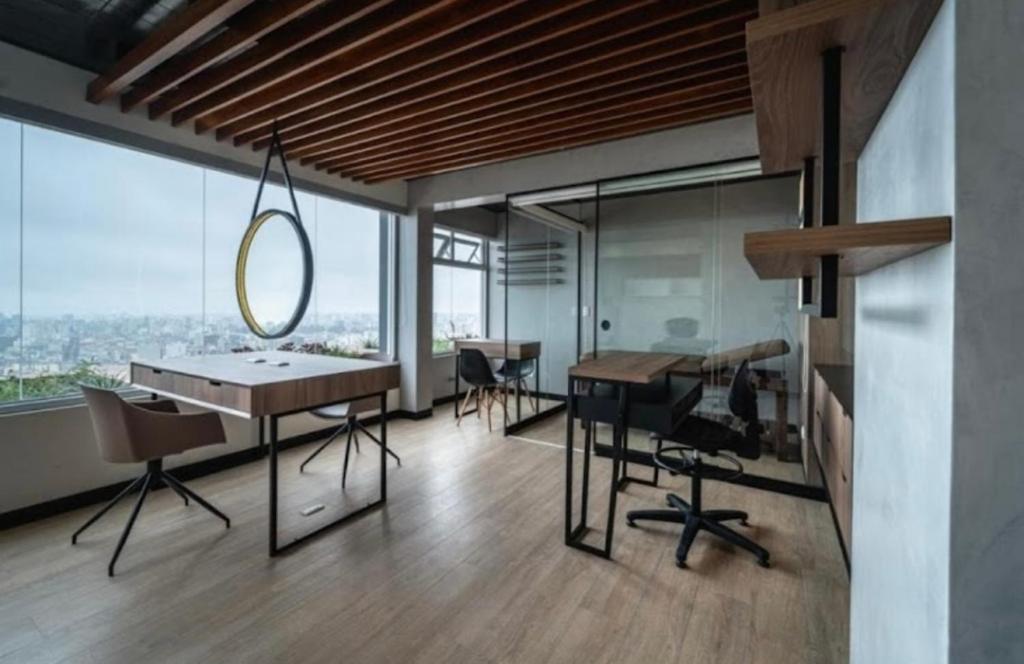 uma sala com uma mesa e cadeiras e uma grande janela em Loft Ale Piso 22 em Lima