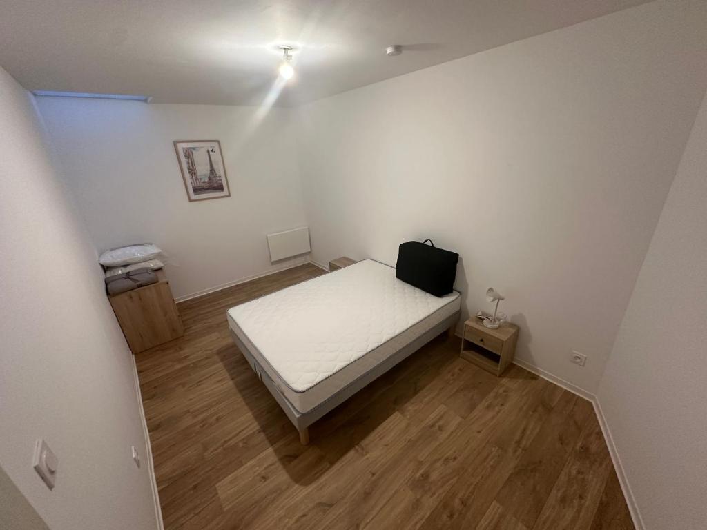 - une petite chambre avec un lit blanc et du parquet dans l'établissement Appartement 4 personnes maximum, à Calais