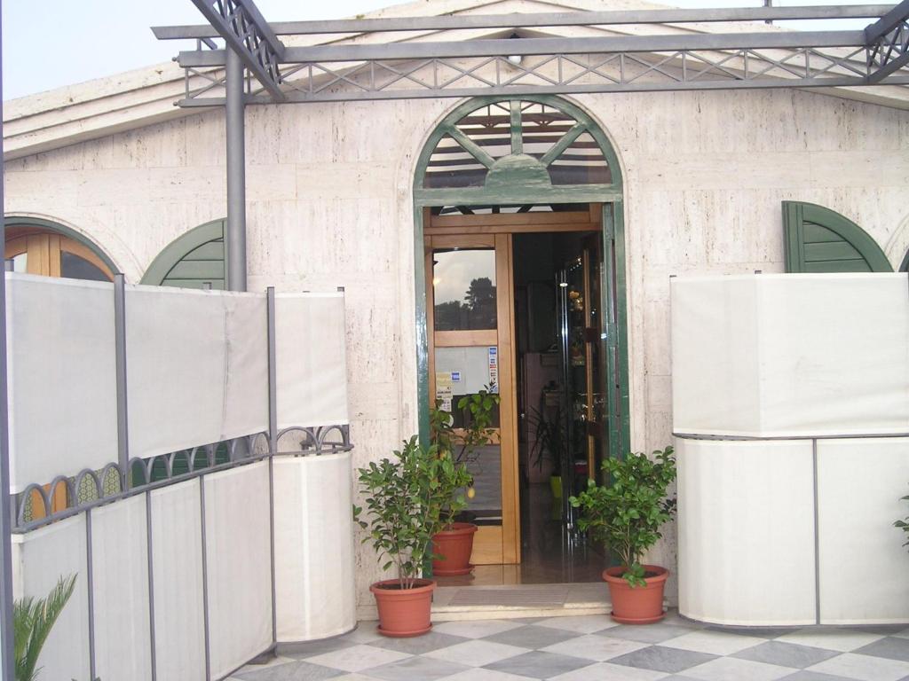 une entrée à un bâtiment avec des plantes en pot dans l'établissement Le Due Sirene, à Piano di Sorrento