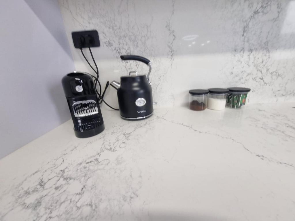 a black appliance sitting on a white marble counter top at chic boutique penthouse walk to the beach ashdod in Ashdod
