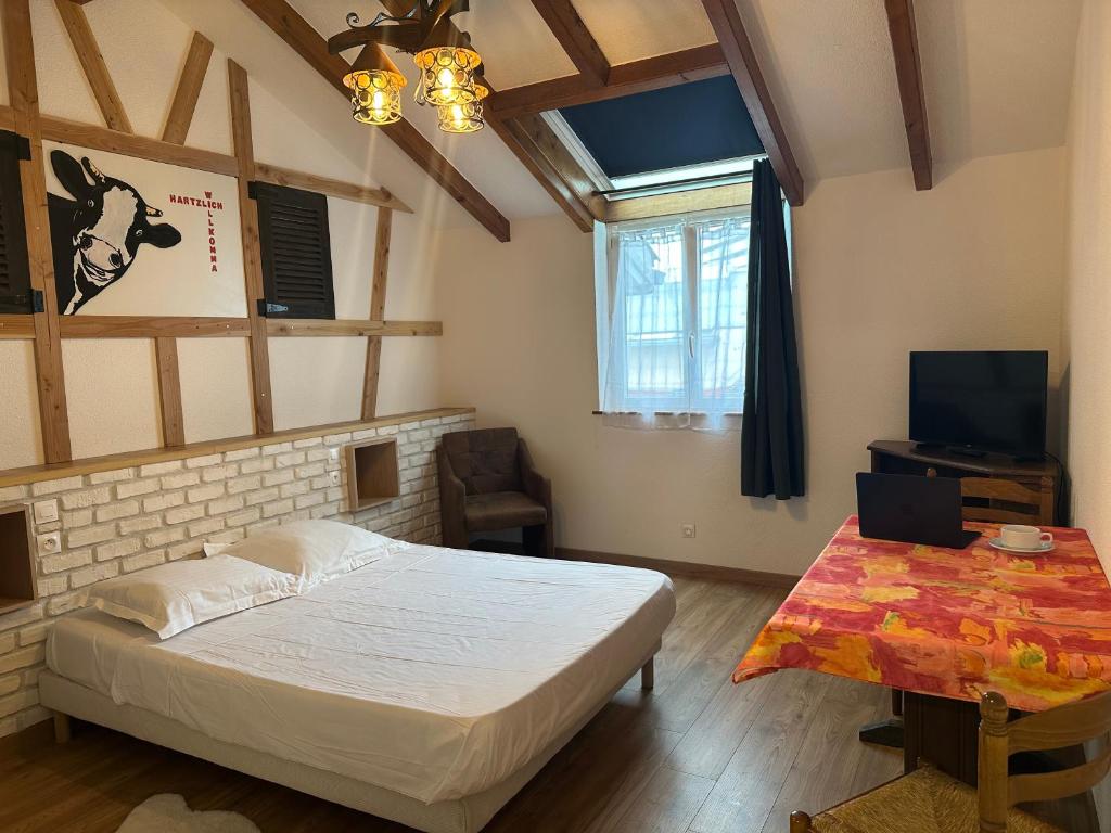 une chambre avec un lit, une télévision et une table dans l'établissement Studio - Hotel Porte de France - Self Check In By Homenhancement, à Saint-Louis