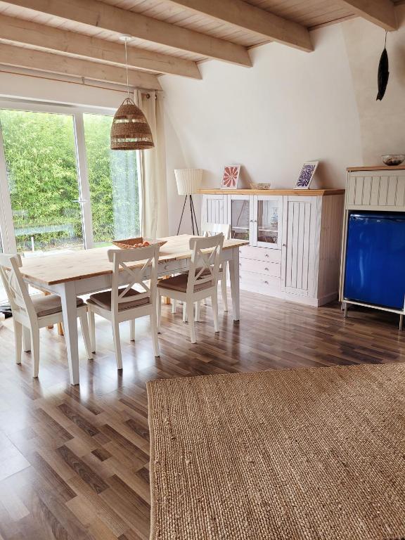 a dining room with a table and chairs and a tv at Ferienhaus ROSA mit Sauna in Dorum-Neufeld
