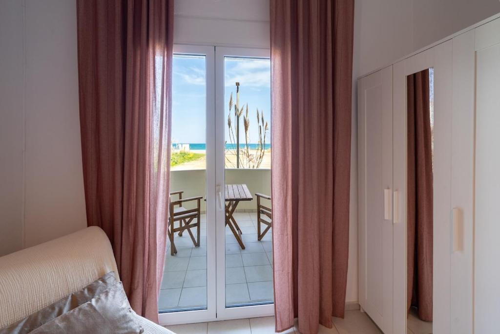 a bedroom with a balcony with a view of the beach at Coastal Key 6 in Gázion