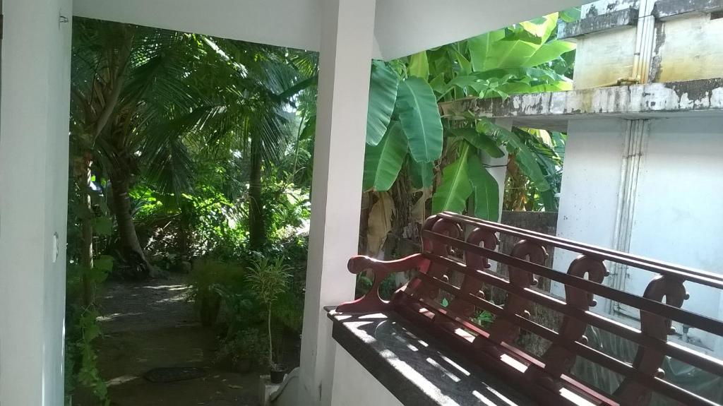 un banco rojo sentado al lado de un edificio en Coconut Grove, en Kochi