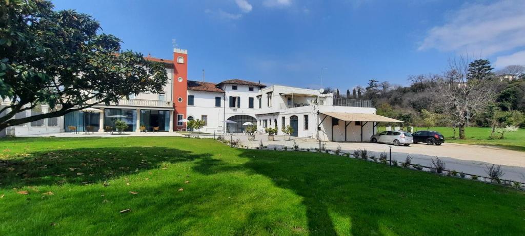 een groot wit huis met een groen gazon ervoor bij Country Esmera in Desenzano del Garda