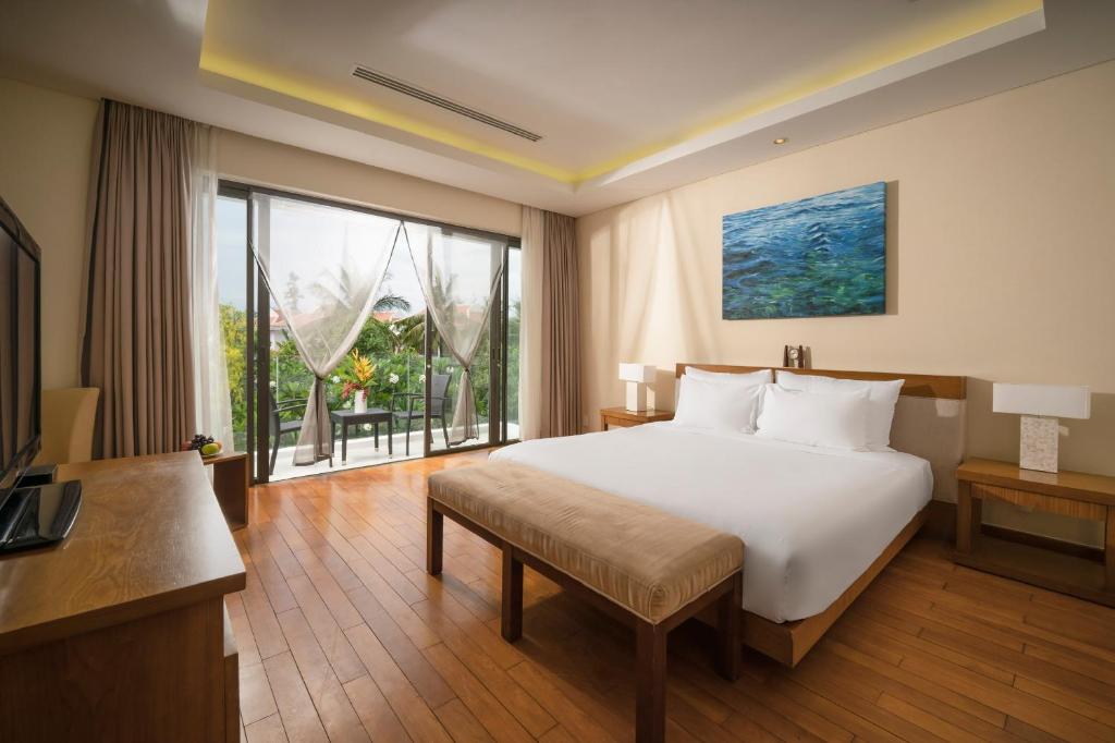Una habitación de hotel con una cama y una ventana grande. en Villa Sân Vườn Lớn DN, en Da Nang
