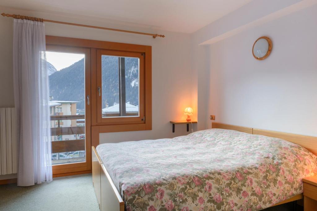 a bedroom with a bed and a large window at Hotel La Nuova Montanina in Auronzo di Cadore