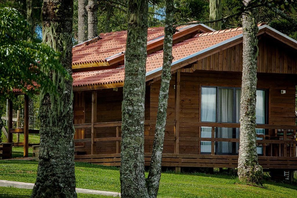 eine Holzhütte mit Bäumen davor in der Unterkunft Boqueirão Hotel Fazenda in Lages