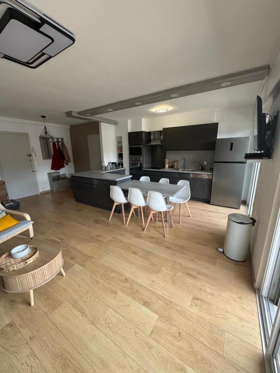 un salon avec une table et des chaises et une cuisine dans l'établissement Les palmiers, à Cavalaire-sur-Mer