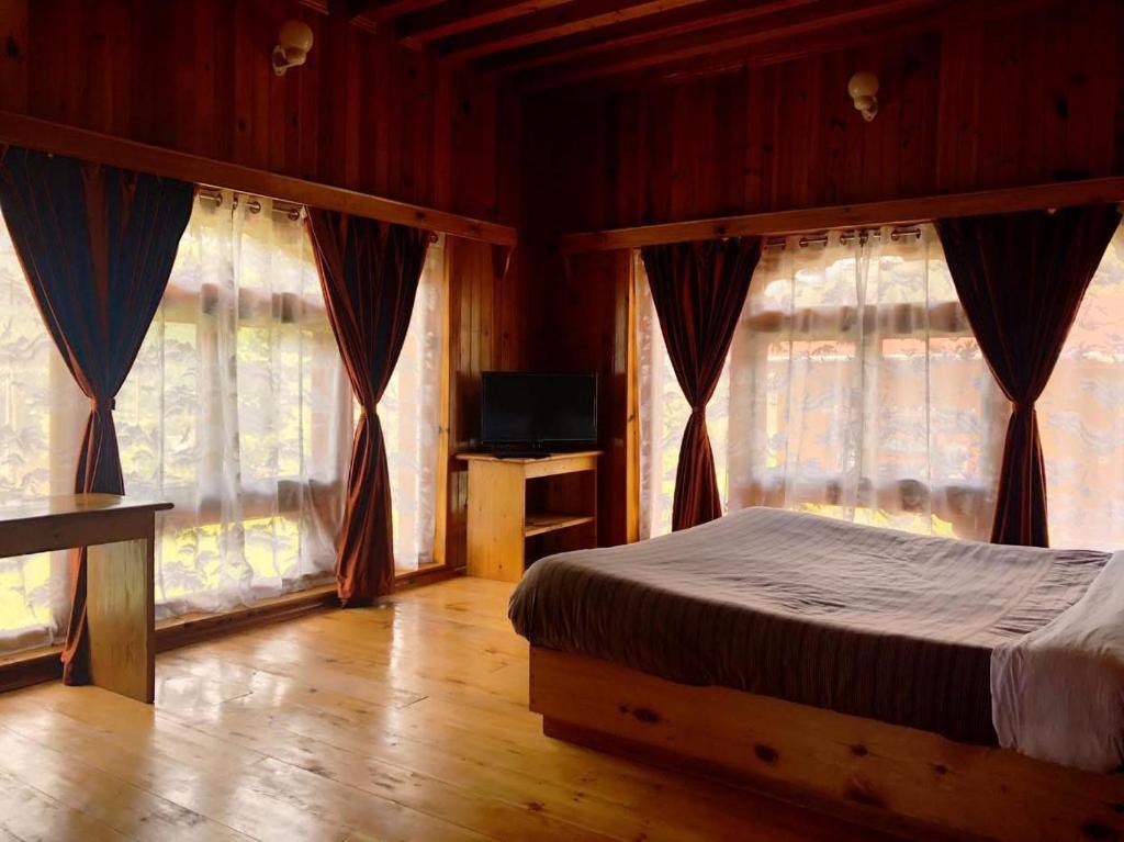 a bedroom with a bed and two large windows at Risum Resort in Ha