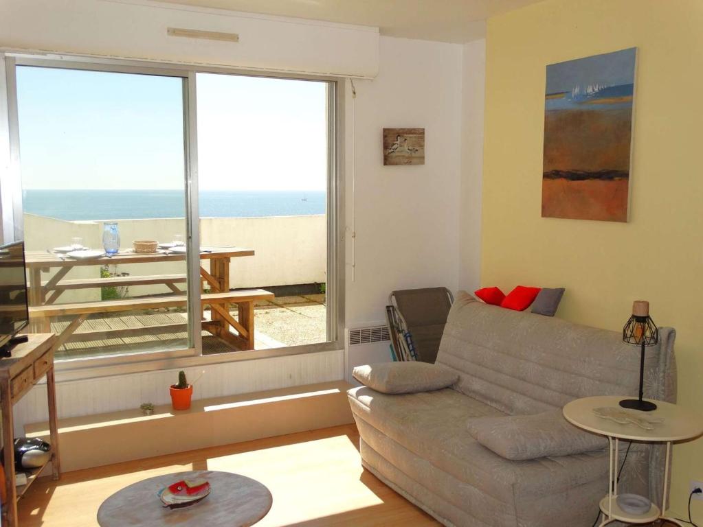 un salon avec un canapé et une vue sur l'océan dans l'établissement Détroit Saint Gilles Croix de Vie, à Saint-Gilles-Croix-de-Vie