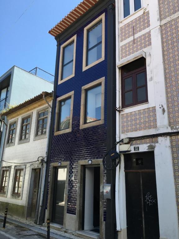 un edificio azul al lado de una calle en Casa da Praça, en Aveiro