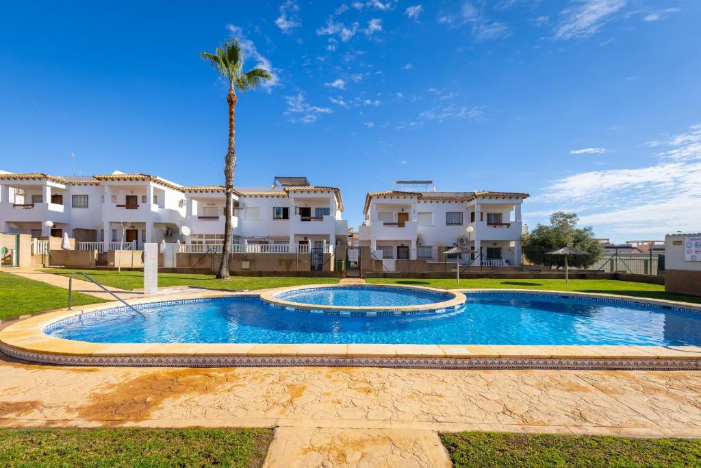 a swimming pool in front of some apartment buildings at Azalea - Stylish Apartment with Rooftop & Pool in Los Altos