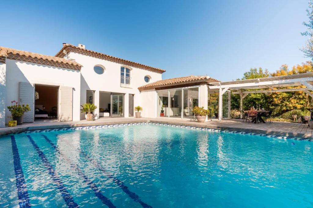 une piscine devant une maison dans l'établissement Villa Armonía piscine privée sur le golf Béziers, à Béziers
