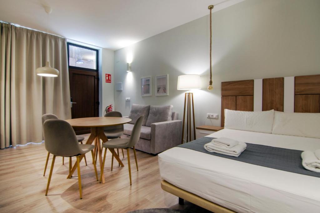 una stanza d'albergo con un letto, un tavolo e delle sedie di VLC HOST - Reino a Valencia