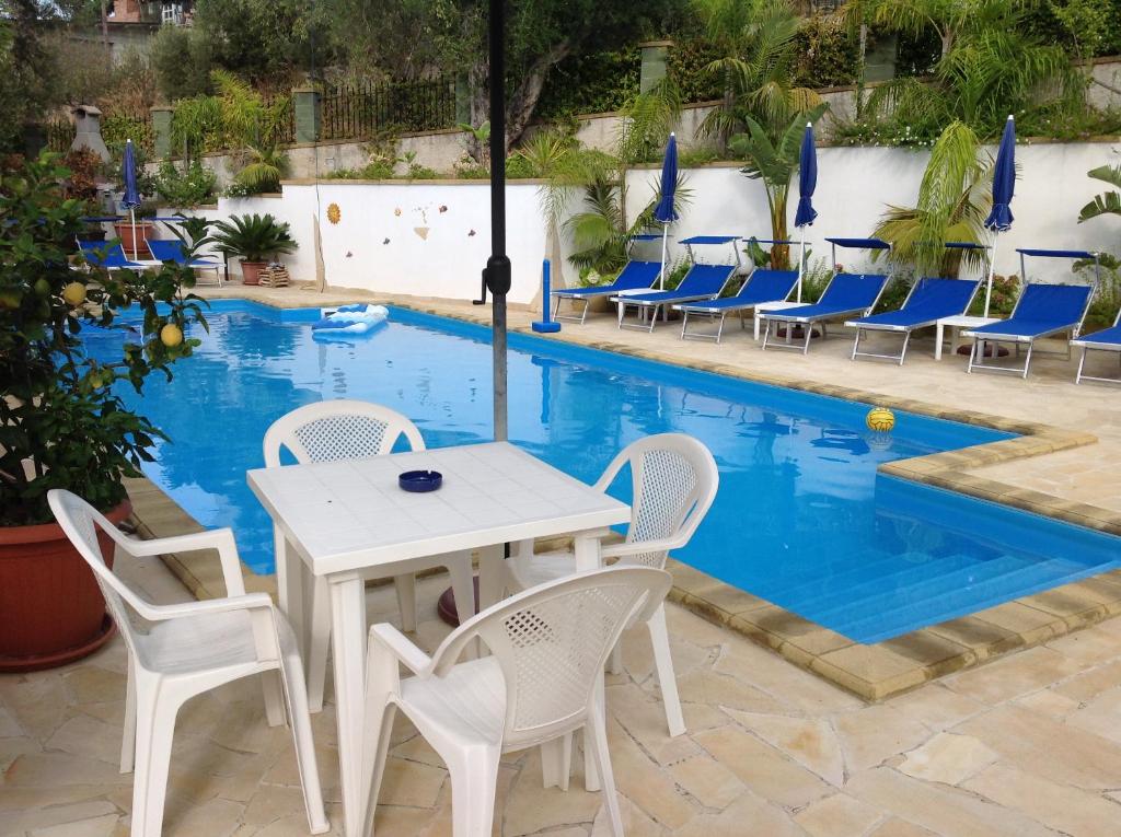tavolo e sedie di fronte alla piscina di Villafiorita a Gioiosa Marea