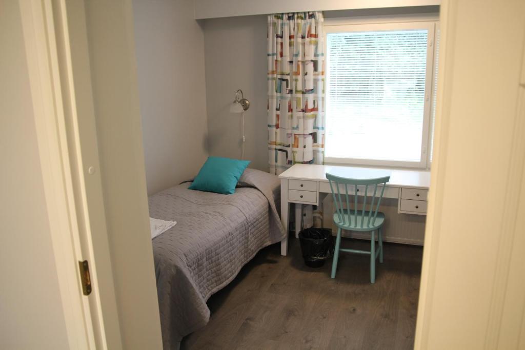 a bedroom with a bed and a desk and a window at Savonlinnan Kansanopisto - Wanha Pappila in Savonlinna
