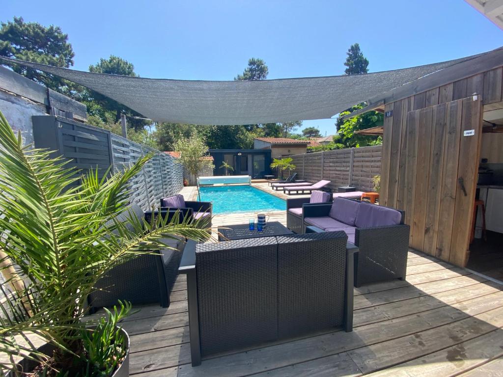 une cour avec une piscine et une pergola dans l'établissement Villa Petite Bleue - Piscine privée chauffée, à Lacanau-Océan