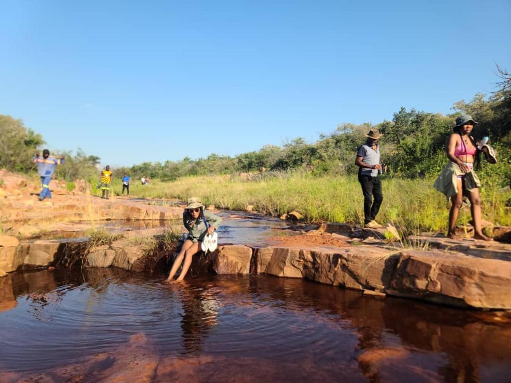 a group of people standing in a river at Kolobeng Cottages in Gaborone