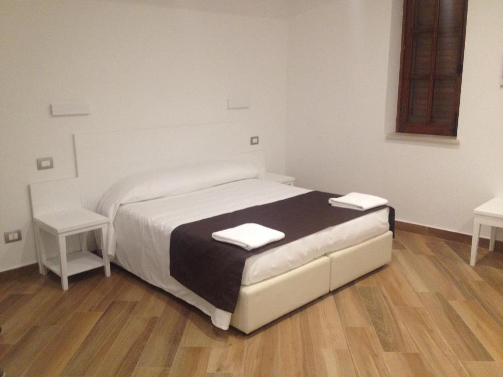 a small bedroom with a bed and two tables at Hotel Il Pirata in Cinisi