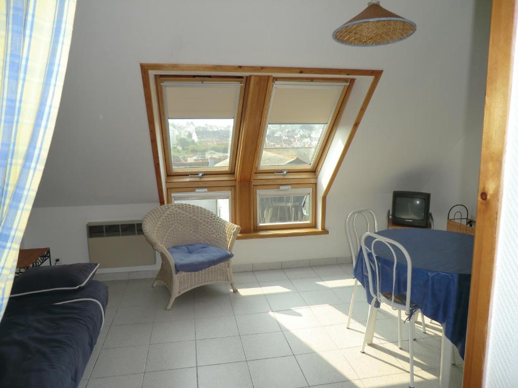 un salon avec une table et des chaises et une fenêtre dans l'établissement Douarnenez tréboul près des plages, à Douarnenez