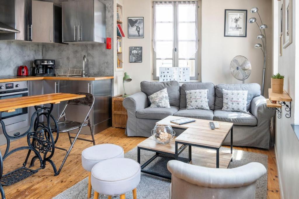 un salon avec un canapé et une table dans l'établissement Appartement pour 2, Place Saint-Sauveur, à Caen